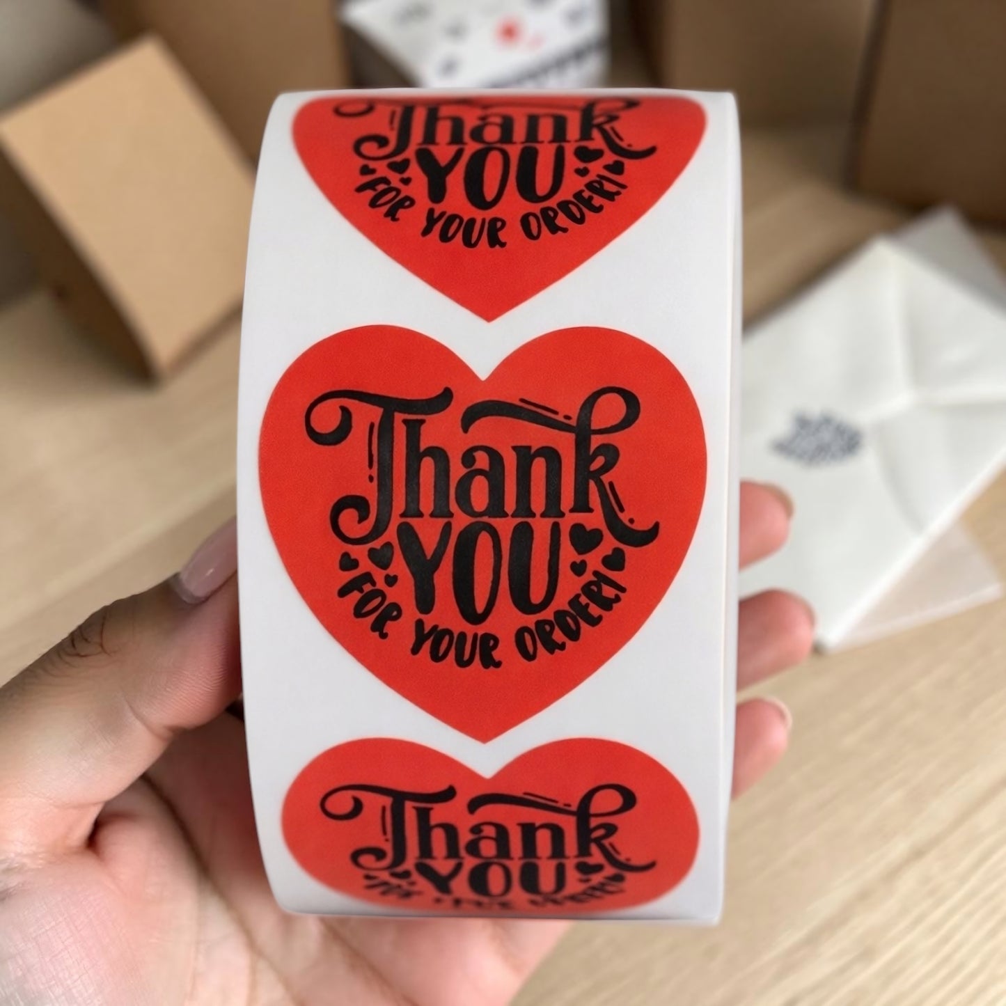 Thank You For Your Order heart sticker roll held in hand
